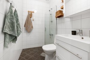Det andre badet er helfliset og består av moderne baderomsinnredning med speilskap, klosett og dusjhjørne med innfellbare vegger.
