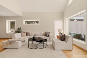 Den gode størrelsen gir ulike møbleringsalternativer. Sofagruppen har fått sin naturlige plassering i den ene delen av stuen. De store vindusflatene åpenbarer den nydelige sjøutsikten.