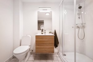 Bad fra 1995 med dusjkabinett fra 2026 som fører vannet direkte til sluk.