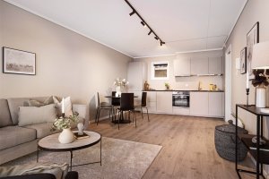 Pent oppholdsrom med praktisk planløsning mot kjøkkenet; store flater og nymalte overflater gir en luftig og innbydende atmosfære.