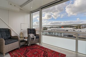 Den innglassede altanen har god størrelse og fungerer som en forlengelse av stuen. Det er flotte fliser på gulvet og downlights i taket.