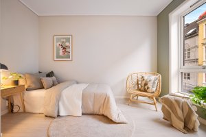 Koselig soverom med en dus farge på veggene. 