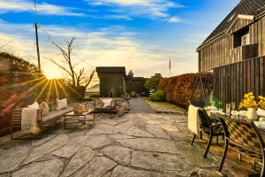 Steinlagte utearealer, beplantning og nivåforskjeller skaper et helhetlig og eksklusivt utemiljø med klare arkitektoniske kvaliteter.