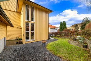 Via tilbygg fra 1997 har boligen skjermet inngangsparti på baksiden av huset. 