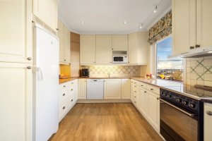 Kjøkkenet er utstyrt med innredning som har godt med skap- og benkeplass. 