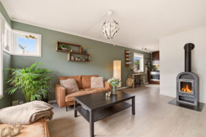 Lys og trivelig stue med rentbrennende peis som skaper lun atmosfære.
