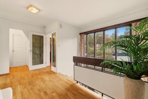 Den romslige hallen har store vindusflater ut mot innkjørsel og inngangsparti til boligen