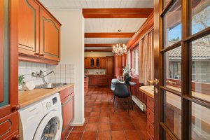 I bakkant av kjøkkenet er det egen sone for grovkjøkken/vaskerom som har dør videre mot husets hovedinngang