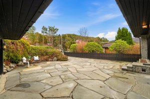 Gjerdet mot naboeiendommen og fin beplantning som skjermer inngangen fra gaten