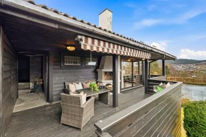 Skjermet og solrik terrasse med utepeis og overbygg