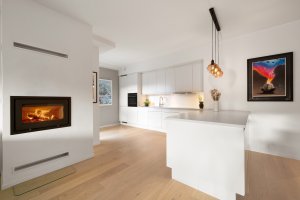 I stuen er det både et plassbygget ildsted og radiator (NIBE avtrekksvarmepumpe) til effektiv oppvarming. 