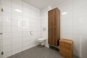 Bad med vegghengt toalett og moderne innredning.