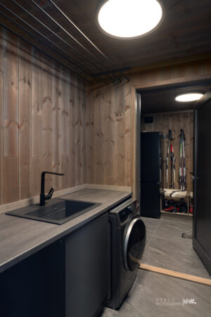 Vaskemaskin i direkte tilknytning til bod og inngangssone, noe som gir en god flyt i hverdagen. Takhengt tørkestativ over benken og kombi vask/tørk maskin.