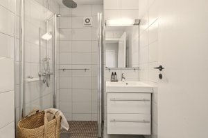 Helfliset bad med gulvvarme, moderne innredning og dusjhjørne. Det er elektrisk avtrekksvifte.