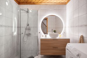 Bad med fliser på gulv/vegger og praktisk innredning.