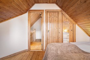 Soverom på loftet med tradisjonelle materialvalg og god romfølelse. Integrert skapplass. 