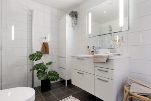 Innfellbare dusjvegger, innredning med god skap og skuffeplass samt speil med innfelt belysning