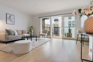 Lys og innbydende stue med fint parkettgulv og store vindusflater