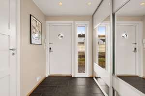 Velkommen inn | Pent inngangsparti med fliselagt gulv med varmekabler og innfelt downlights i taket | Stor speilskyvedørsgarderobe