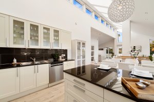 Stort og luftig kjøkken med spiseplass ved kjøkkenøyen som rammer inn kjøkkensonen