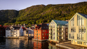 Byggene har saltak og ligger på tvers av kaifronten (som gamle sjøhus). 