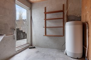 KJELLERETASJE HOVEDBOLIG - Vaskerom på 7.8 m² med utgang til hagen på kortsiden av huset