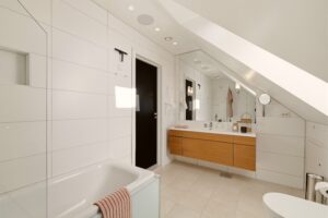 Det flotte badet oppe har god størrelse, tilpasset baderomsinnredning med stort speil og praktisk badekar med tilhørende dusjevegg. Det er downlights i himlingen og innfelte takhøytalere.