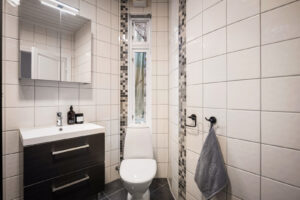 Badet inneholder servant med møblement/speilskap og belysning, overskap, toalett, dusjvegger i glass, dusjgarnityr og opplegg for
vaskemaskin