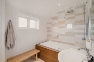 Badet har marmorfliser på gulv, marmorfliser/malt panel på vegger og malt panel
m/spotlights i himling