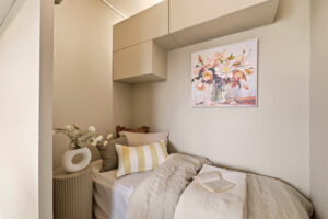 Koselig sovealkove med vegghengte skap. Alkoven er malt i samme fargenyanse som stuen, slik at man får et helhetlig uttrykk.