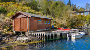 Svaberg og sjø rett utenfor eiendommen. - avbildet båt medfølger.