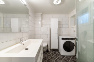 Pent fliselagt bad med plass til vaskemaskin
