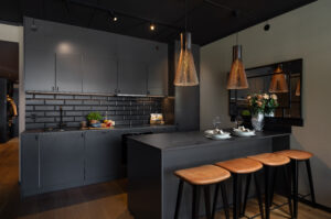 Kjøkkenet er oppgradert med kjøkkenøy og eksklusiv Dekton benkeplate fra Drømmekjøkkenet, samt fliser over benk, spottskinner og belysning som gir et moderne uttrykk.