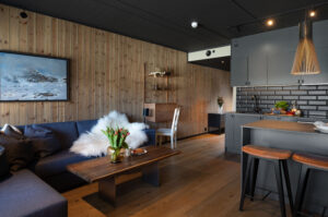 Stuen har en åpen og sosial løsning mot kjøkken og spiseplass, noe som gir en luftig og hyggelig atmosfære 