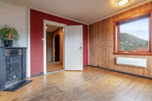 Huset trenger generell modernisering. Bildet viser spisestue med luft-til-luft varmepumpe og eldre vedkamin.