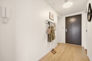 Entré/gang på 5,1 m² med parkettgulv og malte flater.