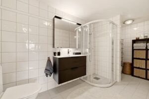 Det helflisede badet har en romslig utforming og er utstyrt med rør-i-rør-system. Ny baderomsinnredning ble installert i 2022 av Laksevåg Rør & Sanitær AS.